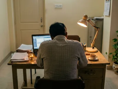 Business owner at desk showing signs of a Vastu-affected struggling business